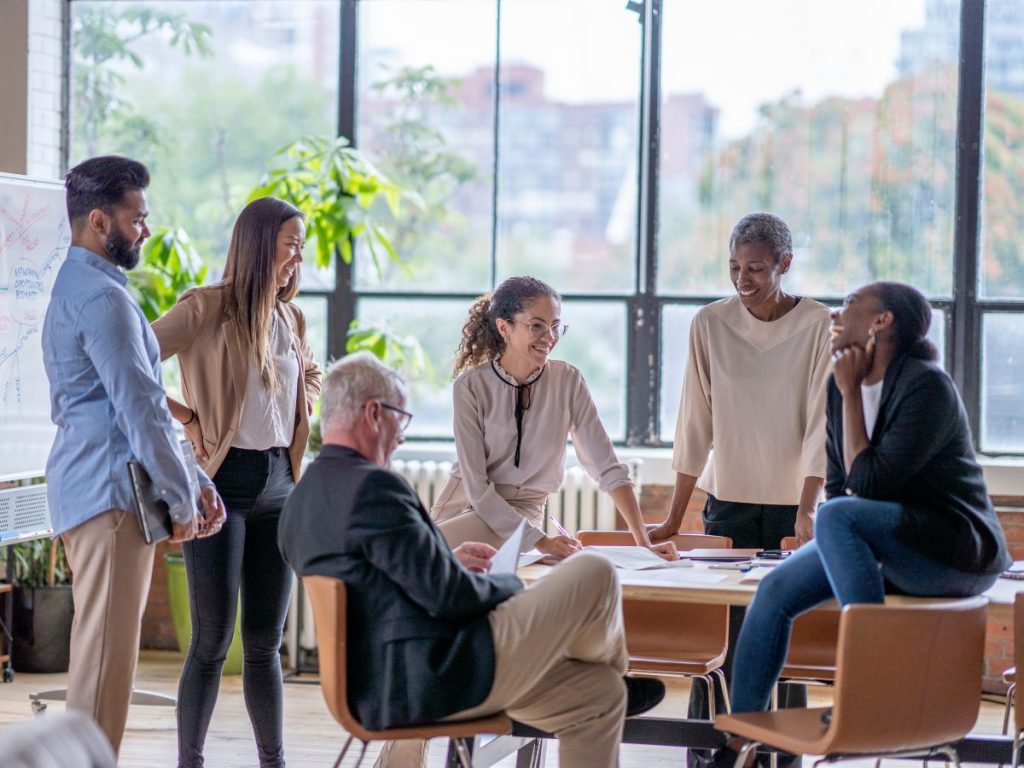A mixed group of male and female colleagues casually conducting an advisory meeting